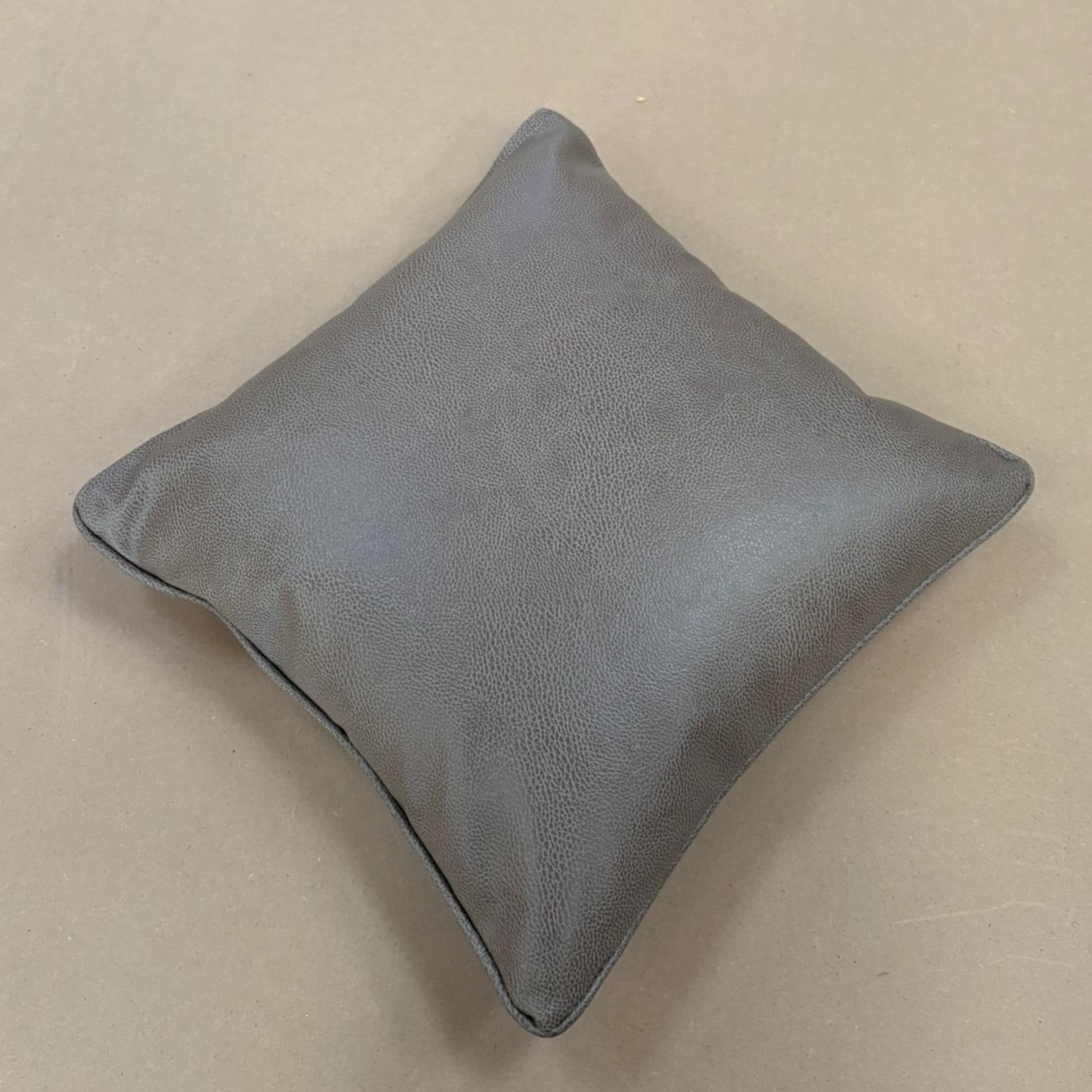 Square scatter cushion in soft grained grey leather with a self-piped edge.