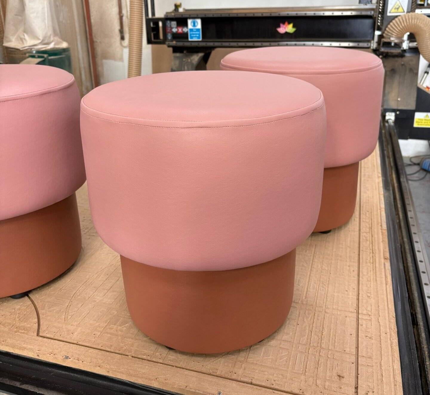Round mushroom stools in blush pink leather over a terracotta base, finished in the workshop.