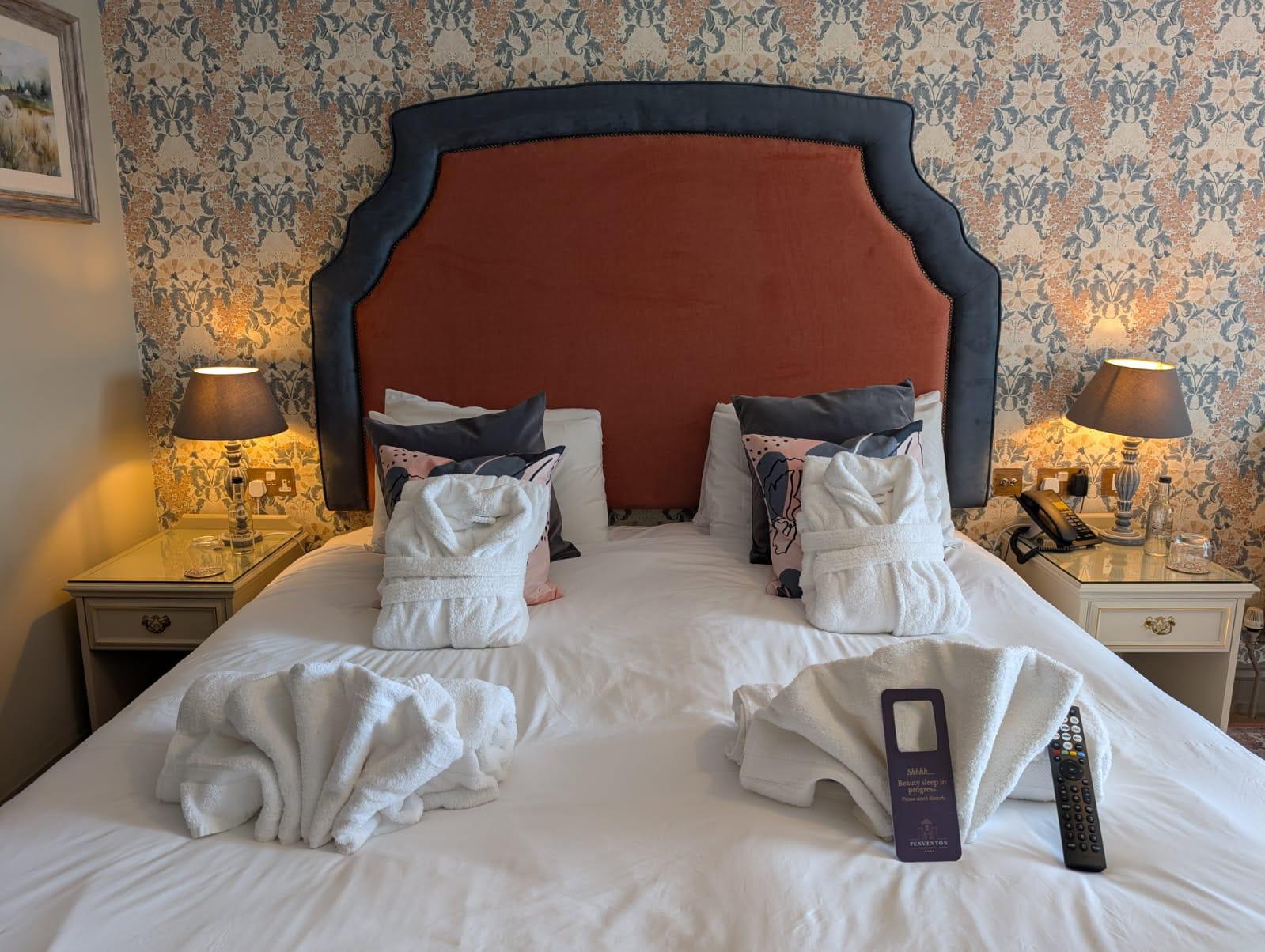 Shaped hotel headboard in rust velvet with a contrasting charcoal surround and stud border.