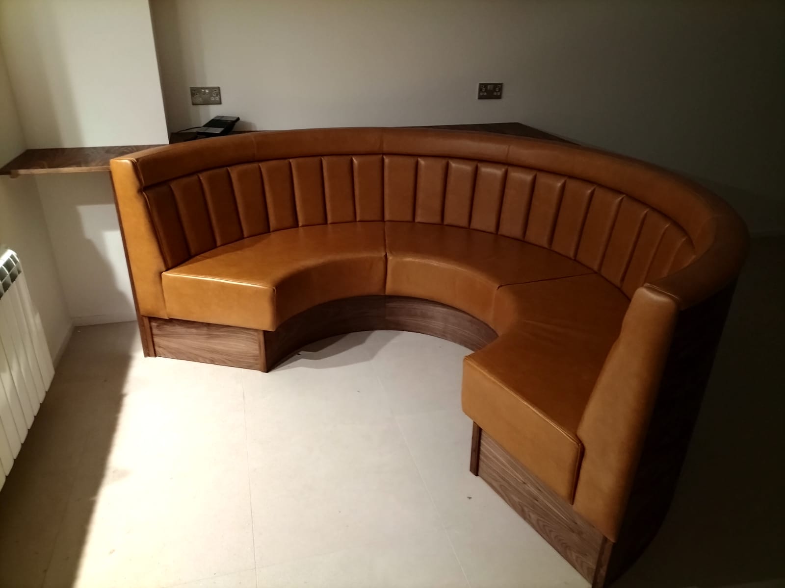 Tan fluted curved booth seating in a commercial venue