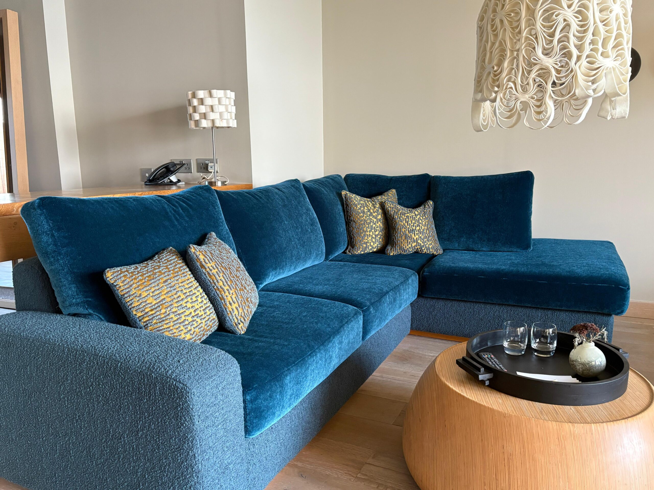Teal velvet and boucle corner seating in a home dining area